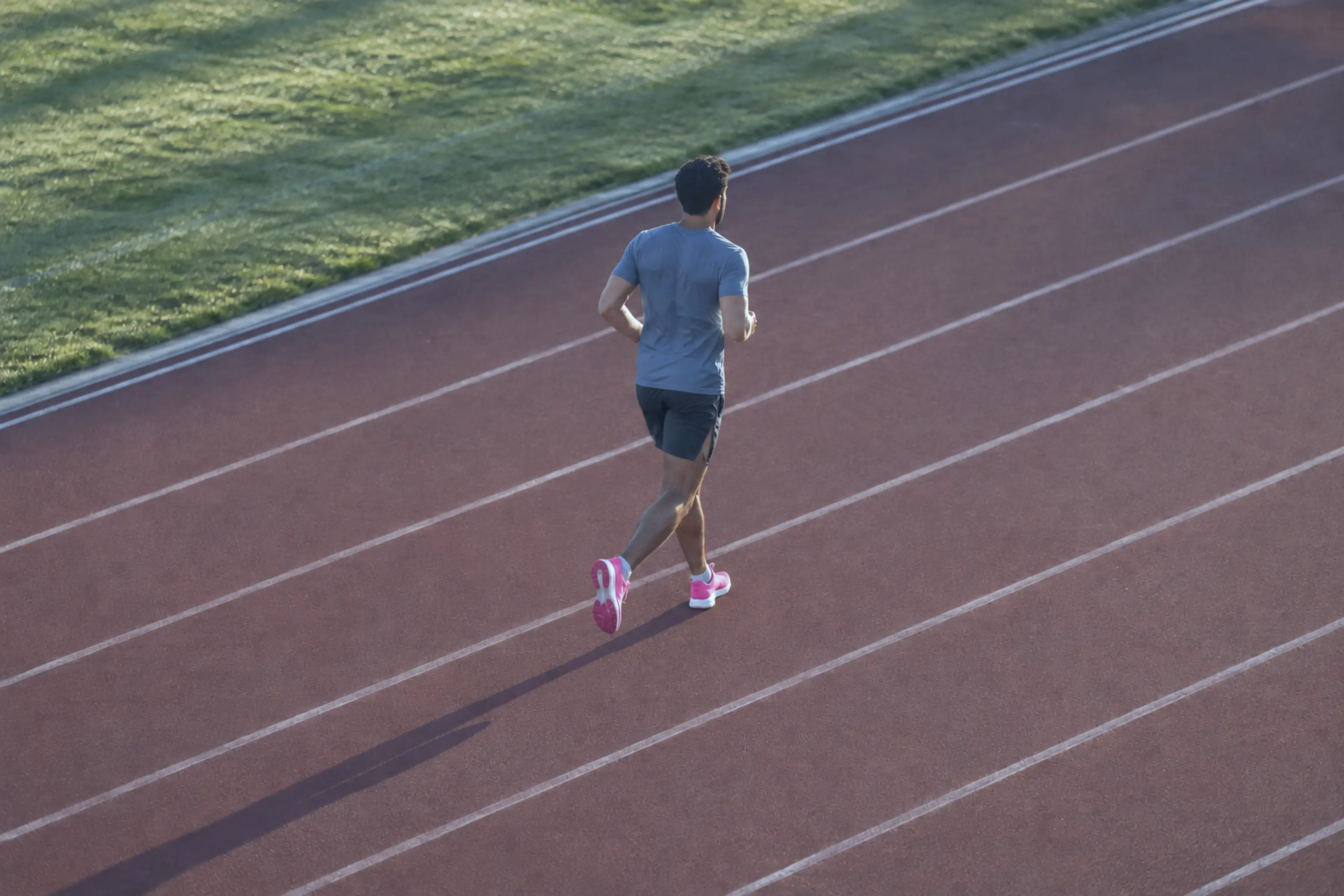 An athlete jogging down after training beside a running track